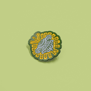 Details of enamel pin depicting Quetzalcoatl.