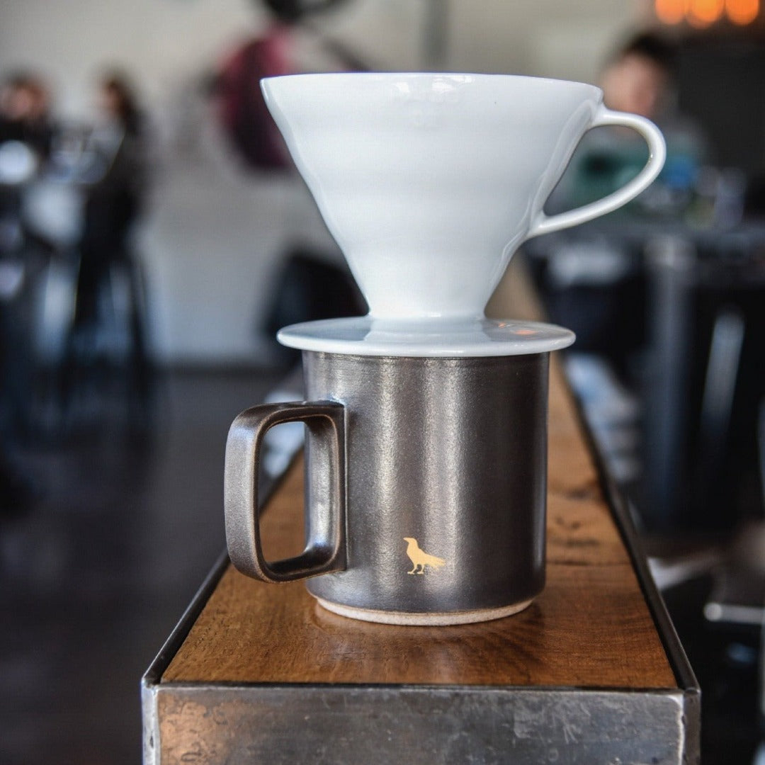 Hario V60 white ceramic brewer in cafe setting.