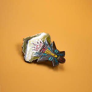 Details of enamel pin depicting African mask.